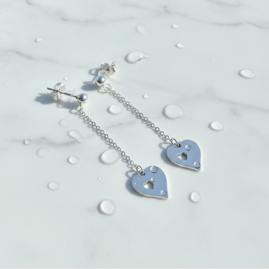 Silver heart-shaped earrings with a lock design on a light background