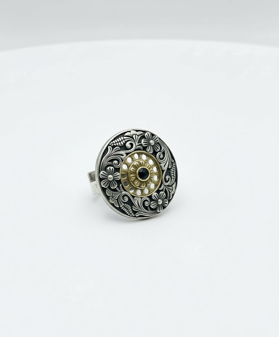 Silver ring with intricate design on a white background