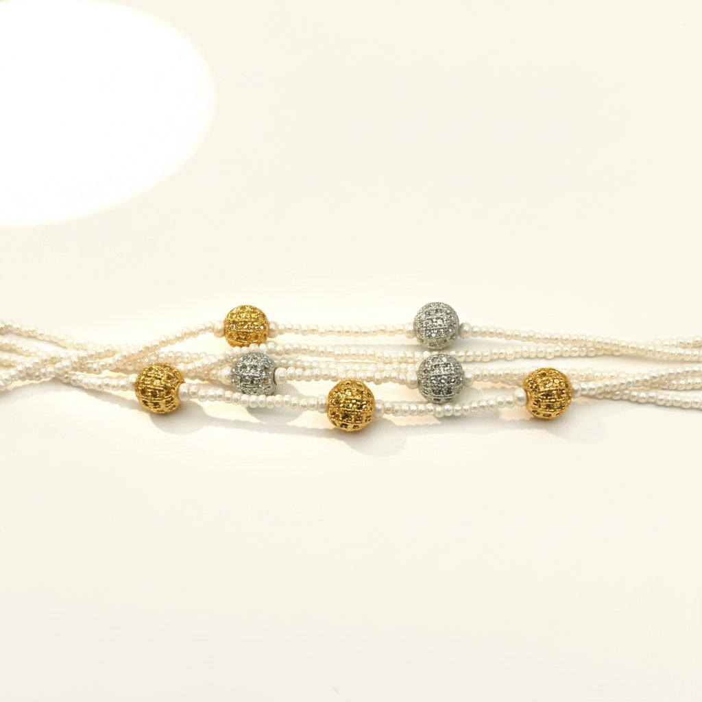 Multi-strand pearl necklace with gold and silver beads on a white background