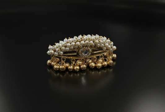 Gold and pearl ring on a black background