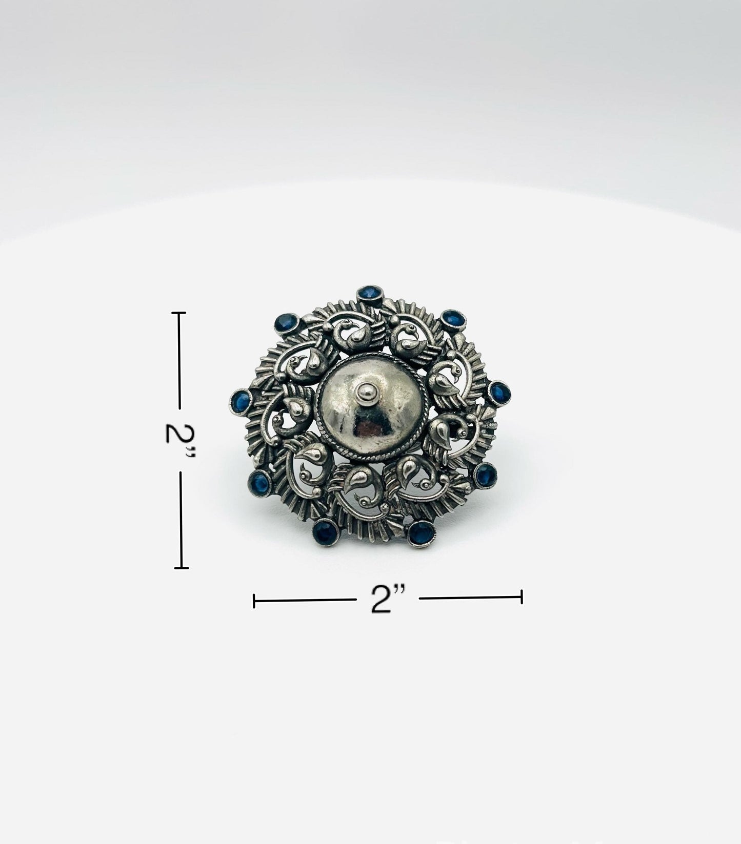 Silver brooch with blue gemstones on a white background