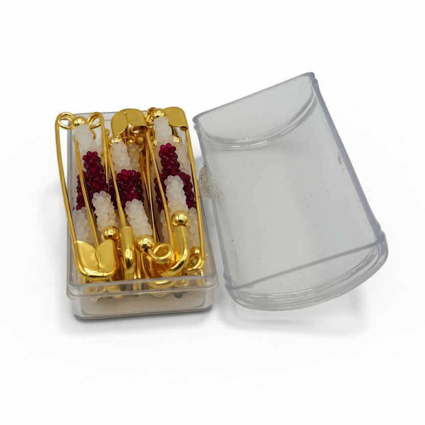 Clear plastic container with gold and red items on a white background