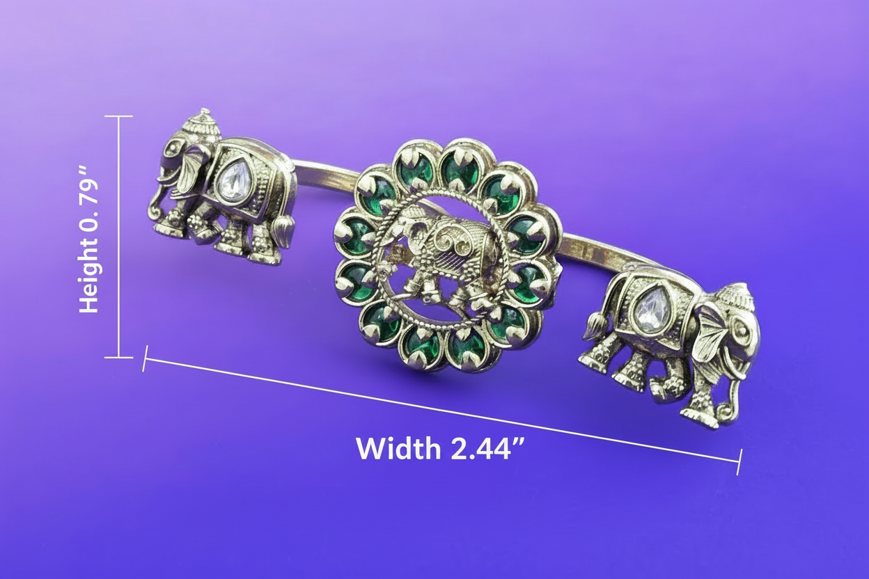 double finger ring with elephant design and green gemstones on a purple background