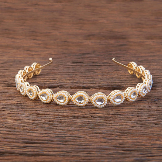 Gold and crystal headband on a wooden surface