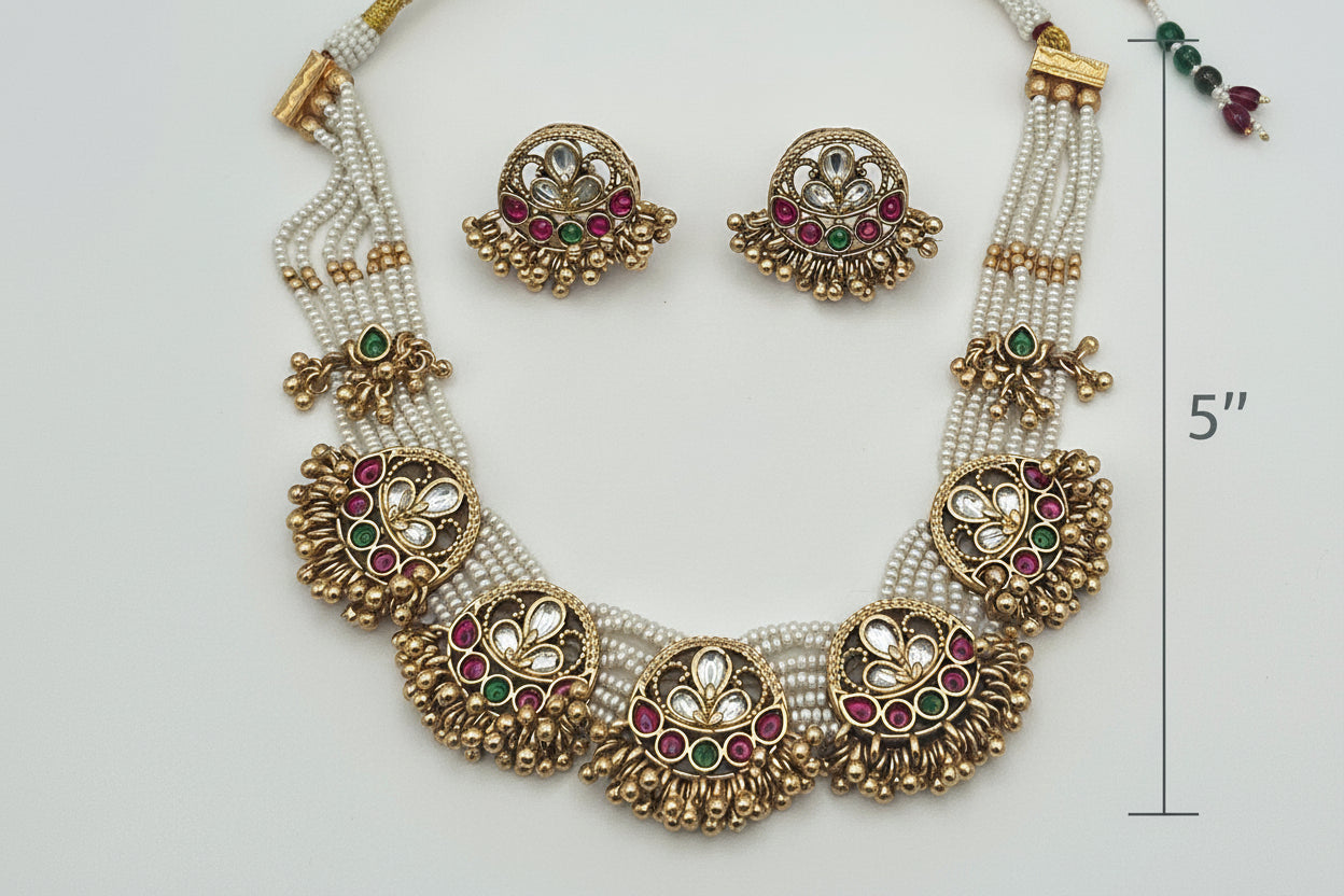Jewelry set including a necklace, and earrings on a white plate with a gray background