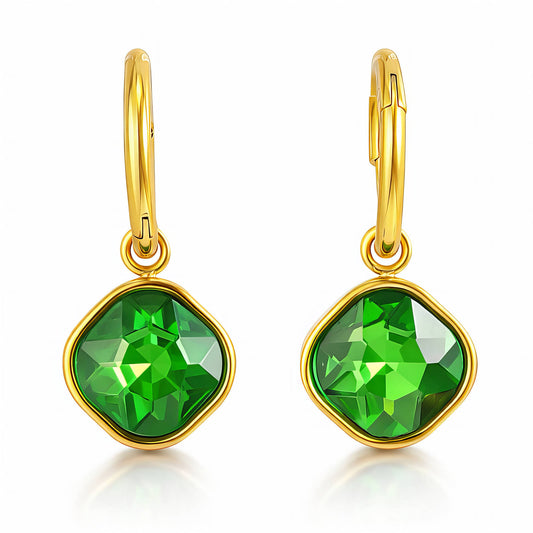 Gold earrings with green gemstones on a white background