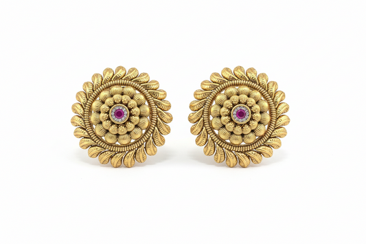 Pair of gold earrings with central gemstones on a white background