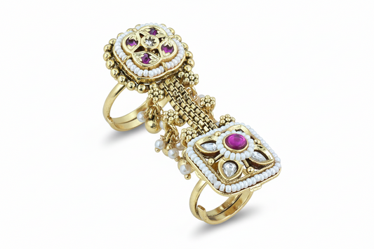 Gold ring with decorative elements on a pink background