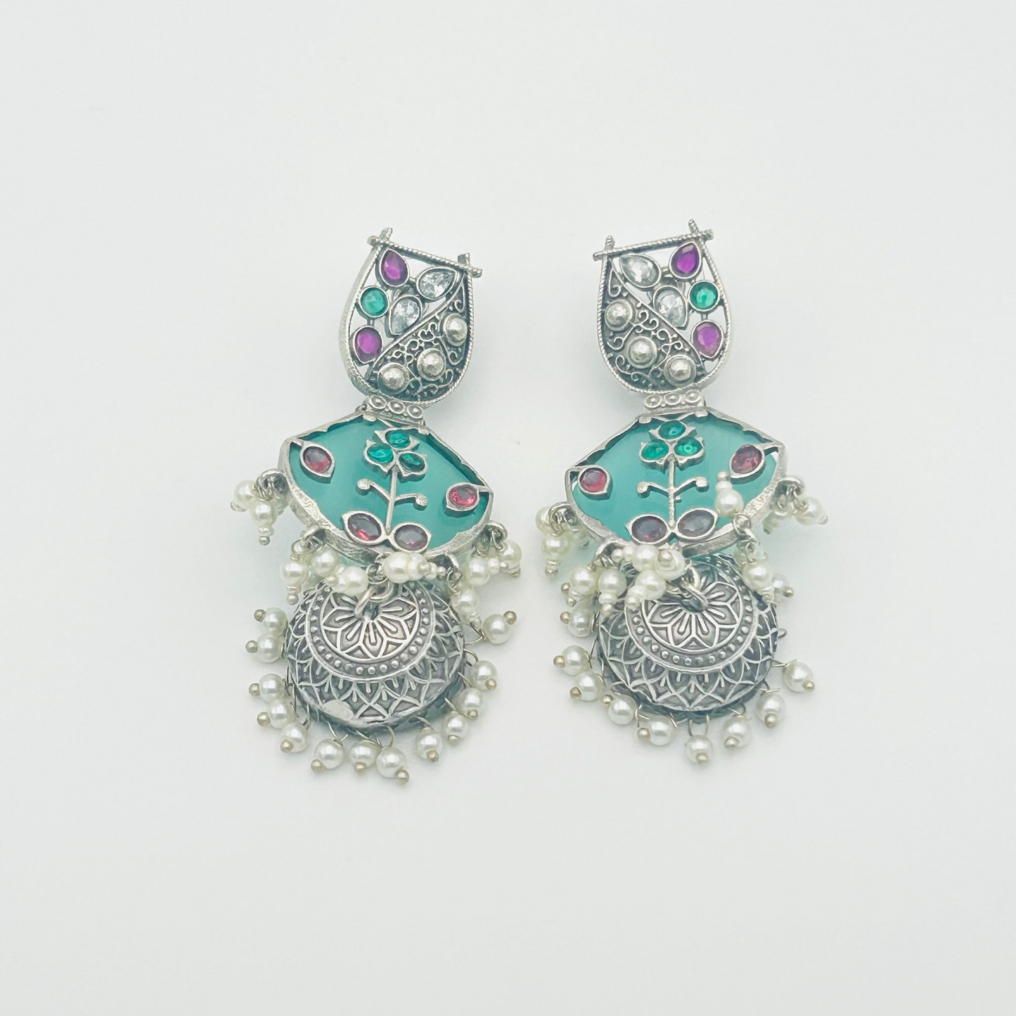 Pair of earrings with turquoise and silver design on a white background