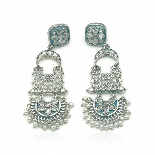 Pair of silver earrings with intricate designs on a white background