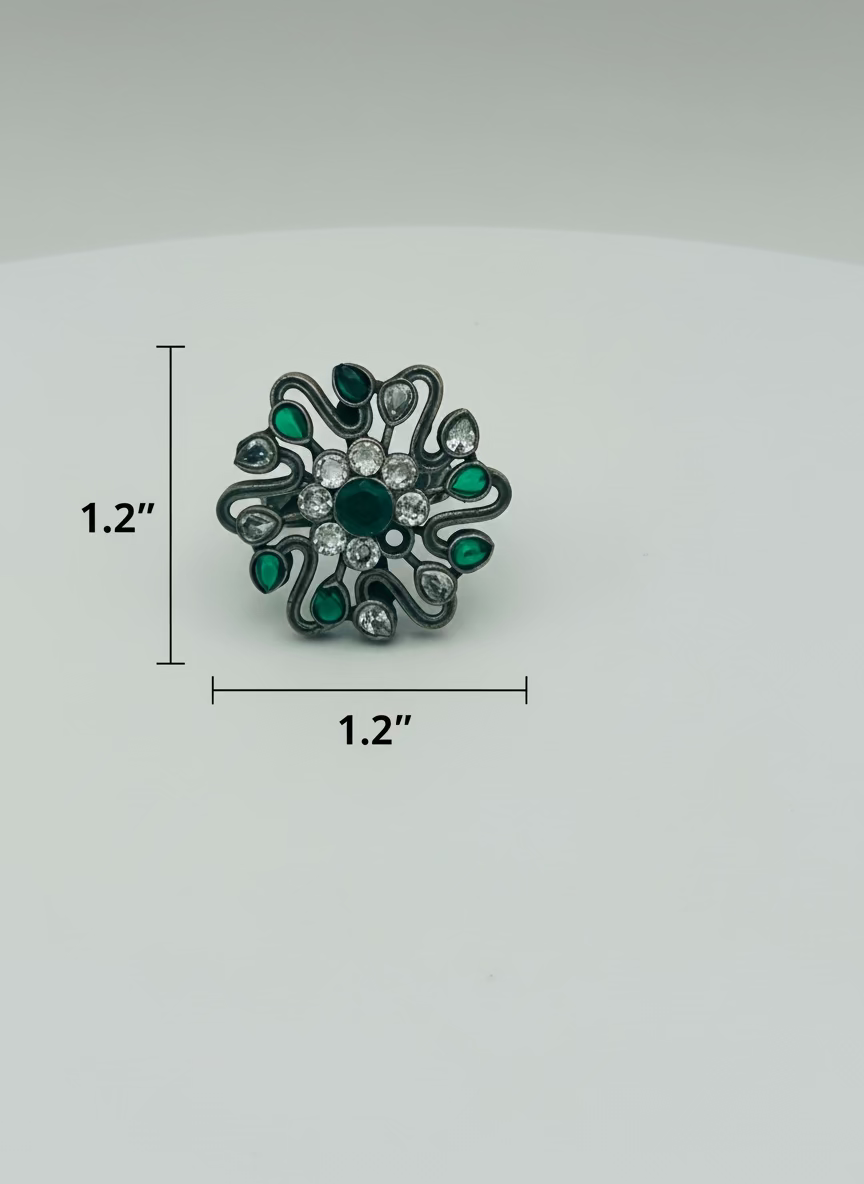 Decorative ring with green and clear gemstones on a white background