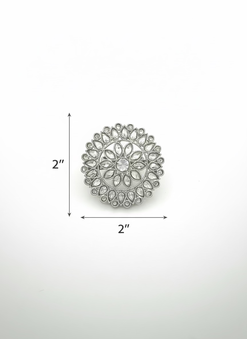 Silver brooch with gemstones on a light gray background