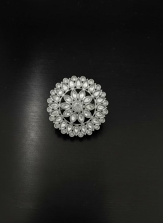 Silver brooch with gemstones on a light gray background