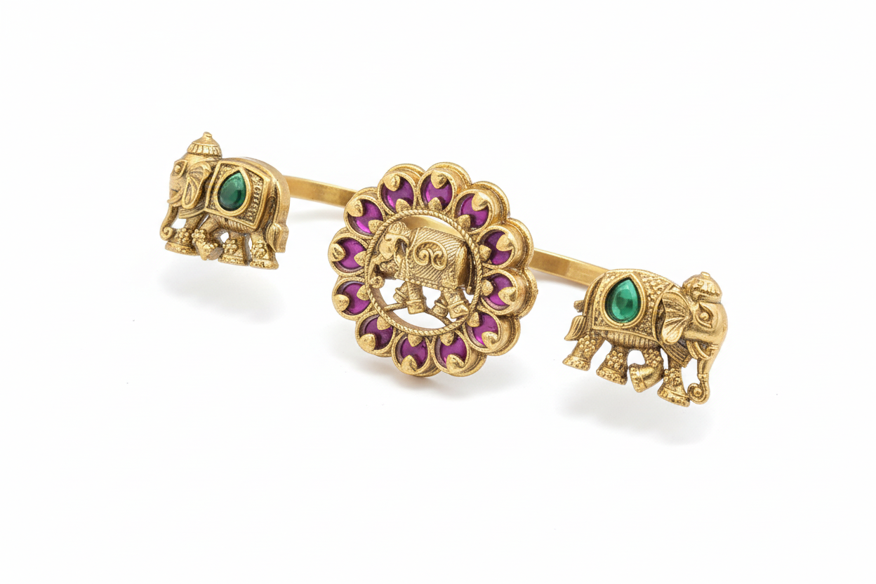 Gold elephant-themed double finger ring with green and purple stones on a white background