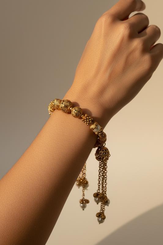 jhumka Gold plated adjustable bracelet with chain pearl detail on a wrist against a neutral background