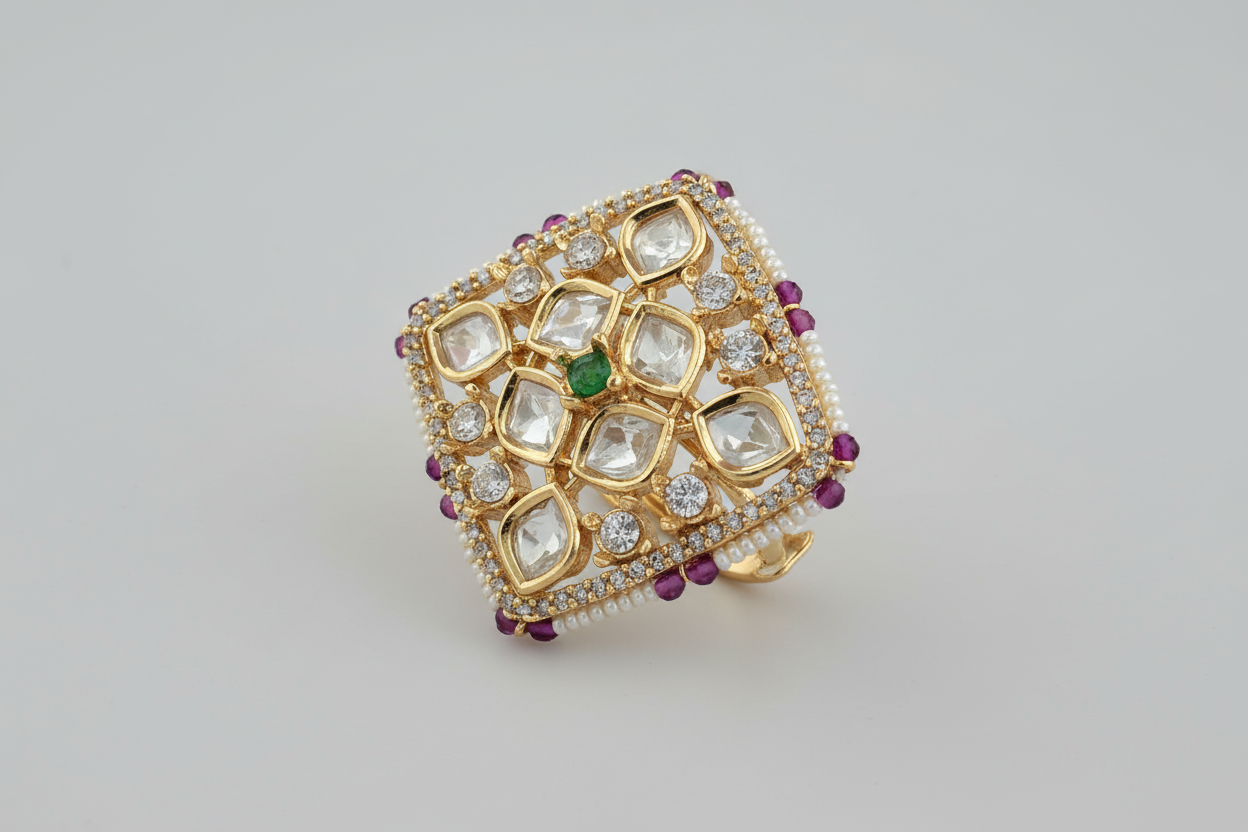 Gold plated ring with gemstones on a light gray background