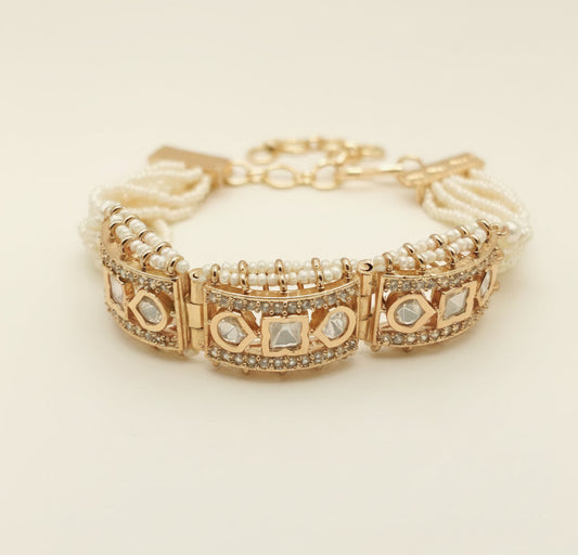 Rose gold plated bracelet with beaded pearl chain traditional jewelry and gemstone accents on a light  background