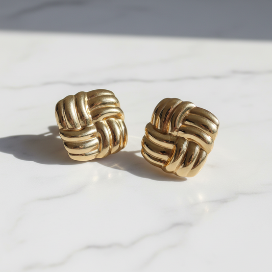 Pair of gold knot earrings on a light background