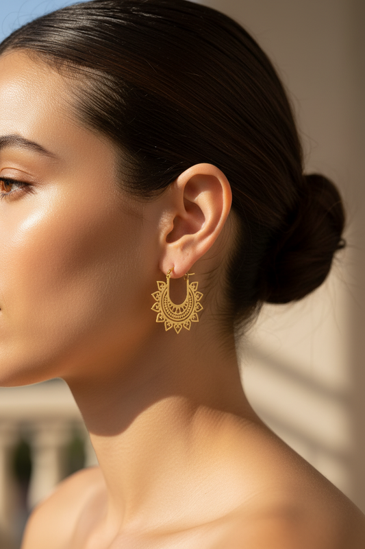 Close-up of a woman wearing gold hoop earrings with a blurred background