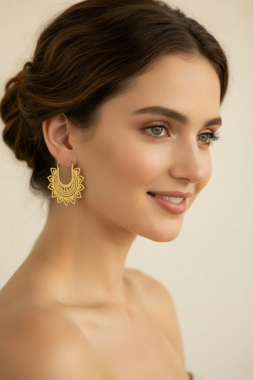 Woman wearing gold earrings with a neutral background