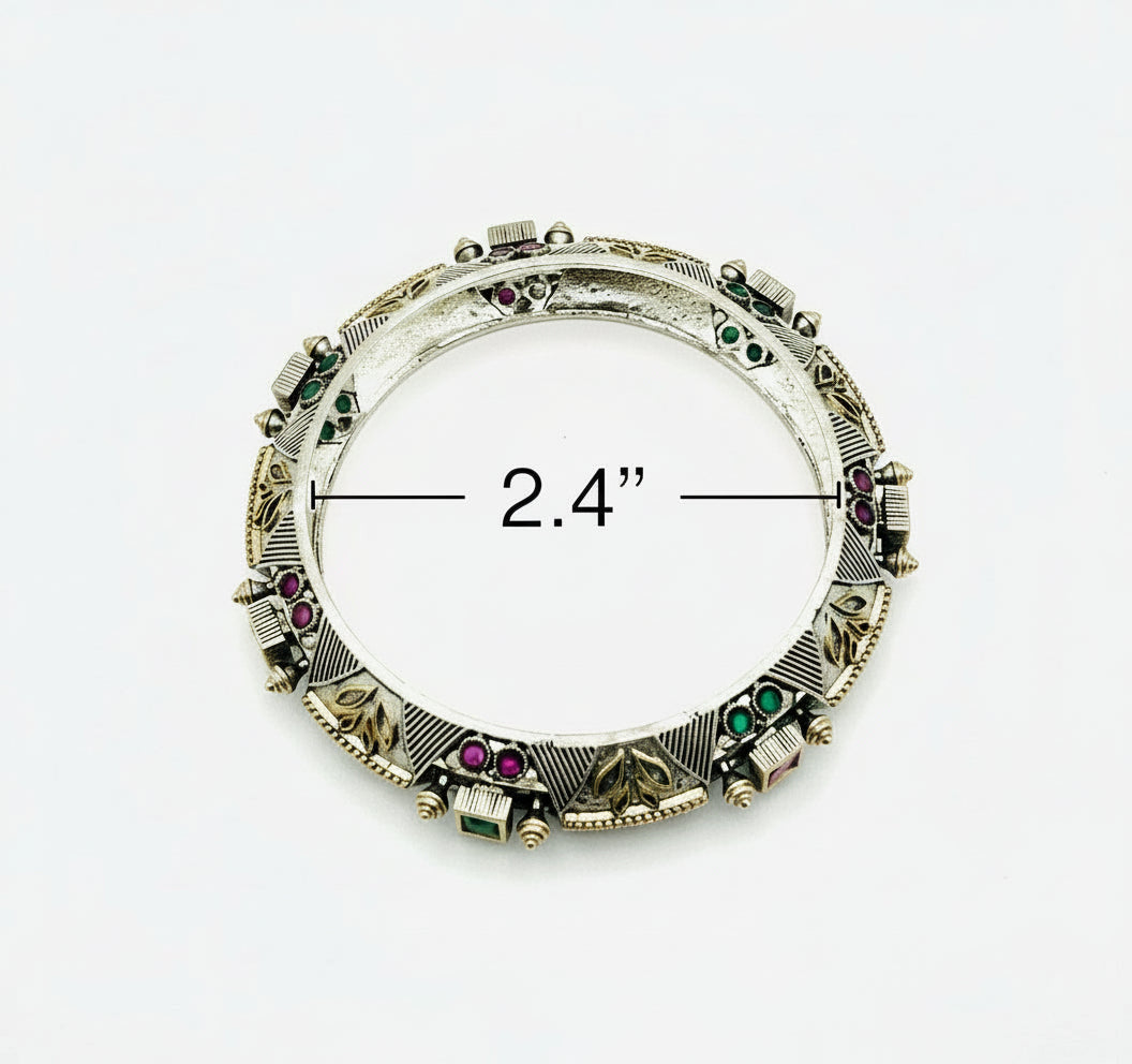 Jewelry brooch with gemstones and measurement label on a white background