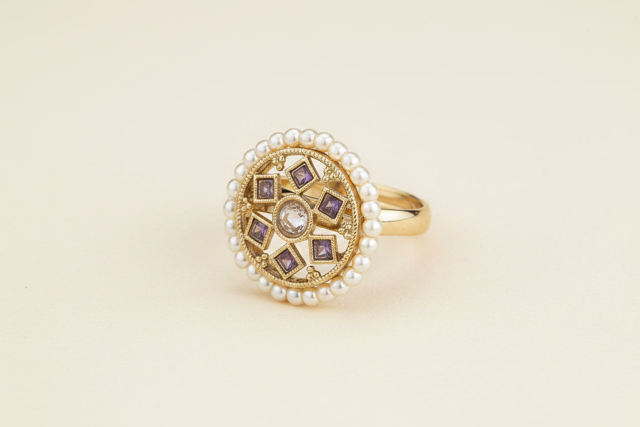 kundan purple stone pearl beaded mehadi Gold plated ring with pearl on a wooden surface
