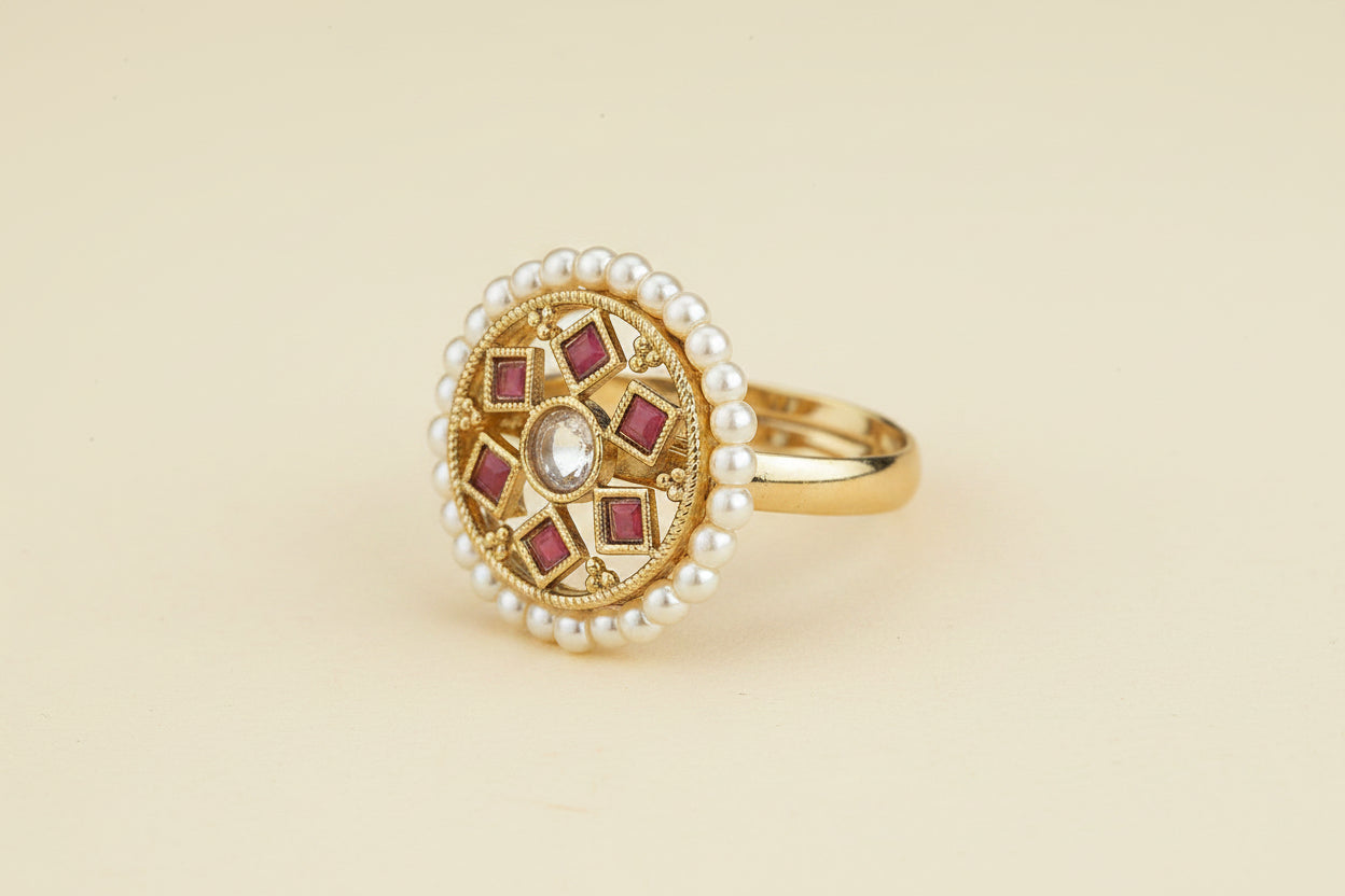 Cocktail antique Gold plated pearl ring with red gemstone accents on a beige background 