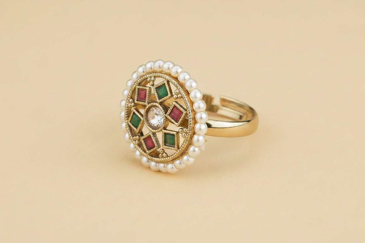 Indian kundan ruby green and red kudan style stone ring with pearls and gemstones on a beige background 