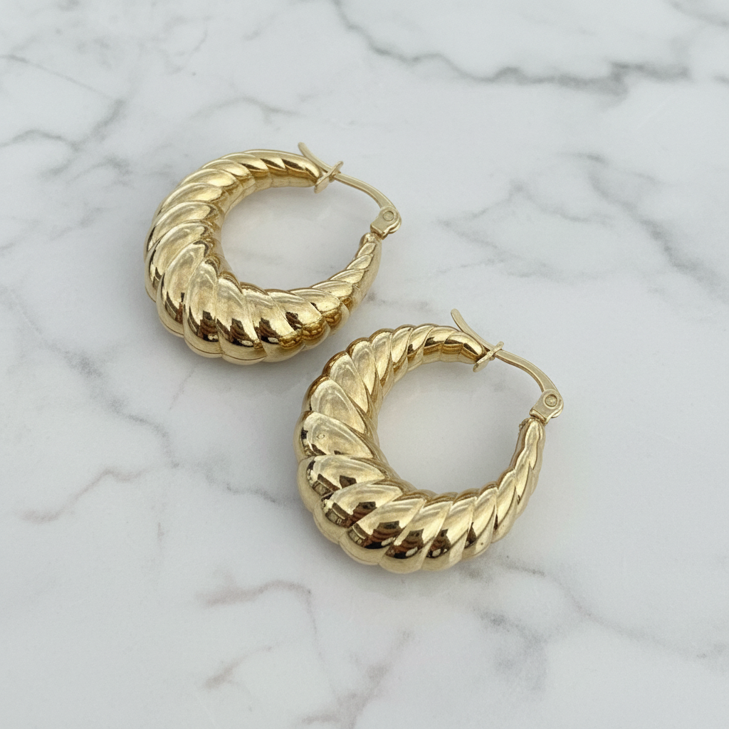 Gold hoop earrings on a textured light blue background