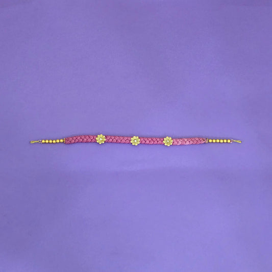 hair band with pink braided design and gold accents on a purple background