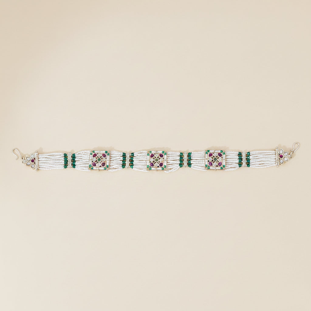 antique Matta patti with layered pearl beaded band ruby green gemstones traditional bridal wedding wear on a beige background