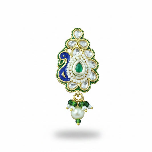Decorative peacock shaped kundan nose clip with green blue and gold elements on a purple background