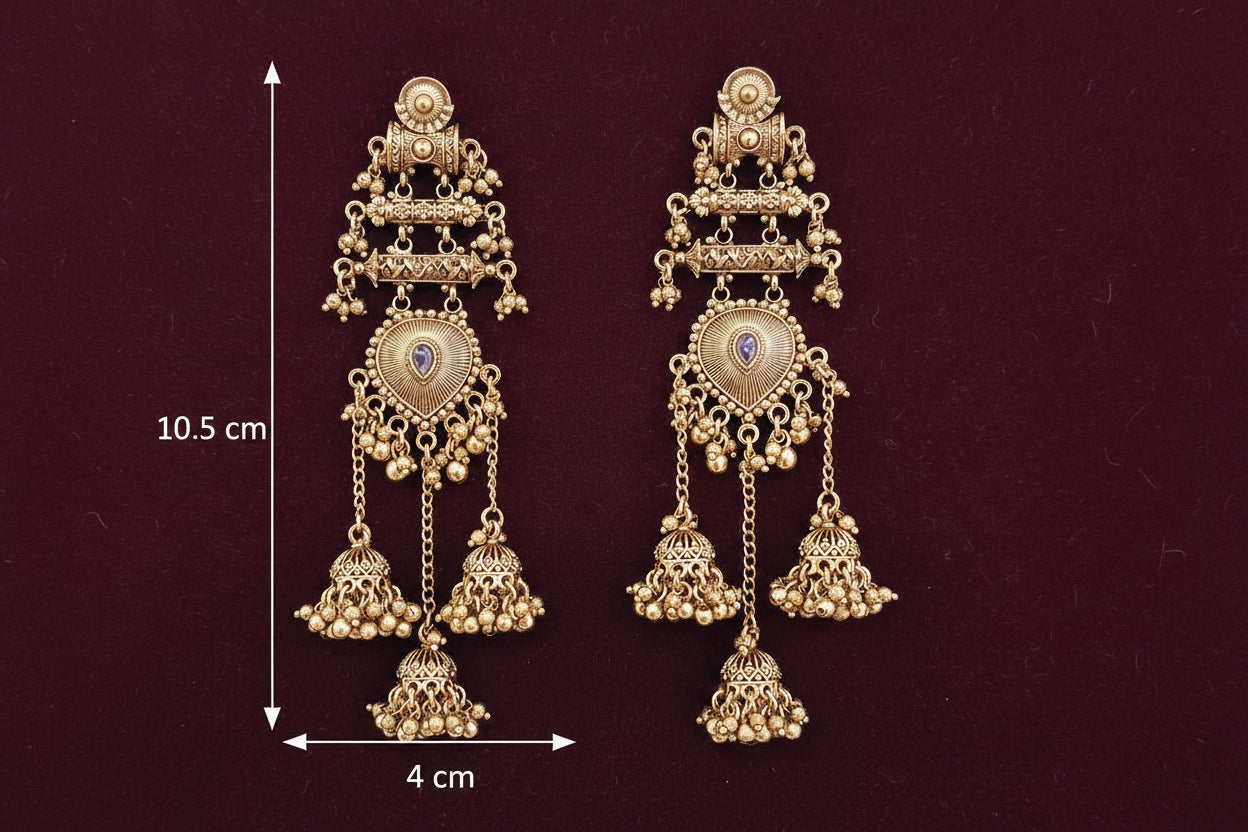 Pair of gold earrings with intricate designs on a teal background