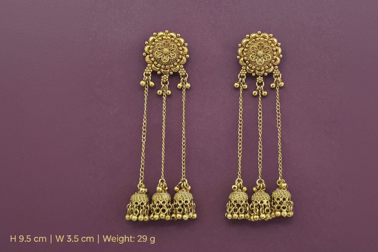 Pair of long kashmiri  gold plated earrings with intricate designs on a purple background