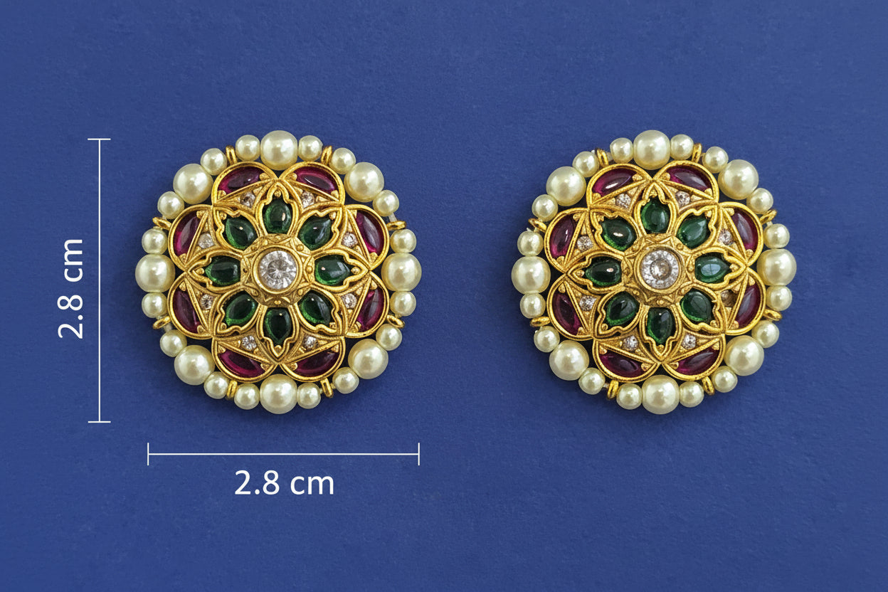 Pair of gold earrings with pearls and gemstones on a blue background