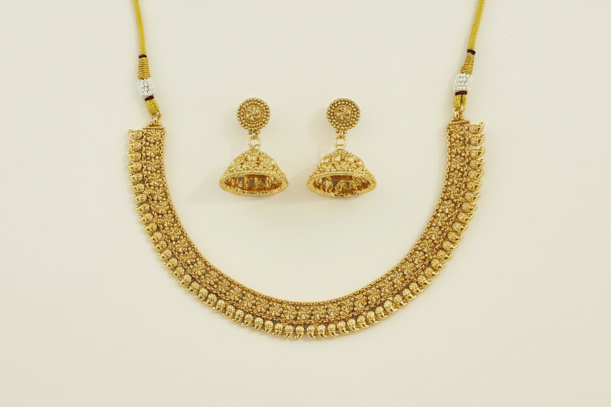 Gold necklace and earrings on a green background