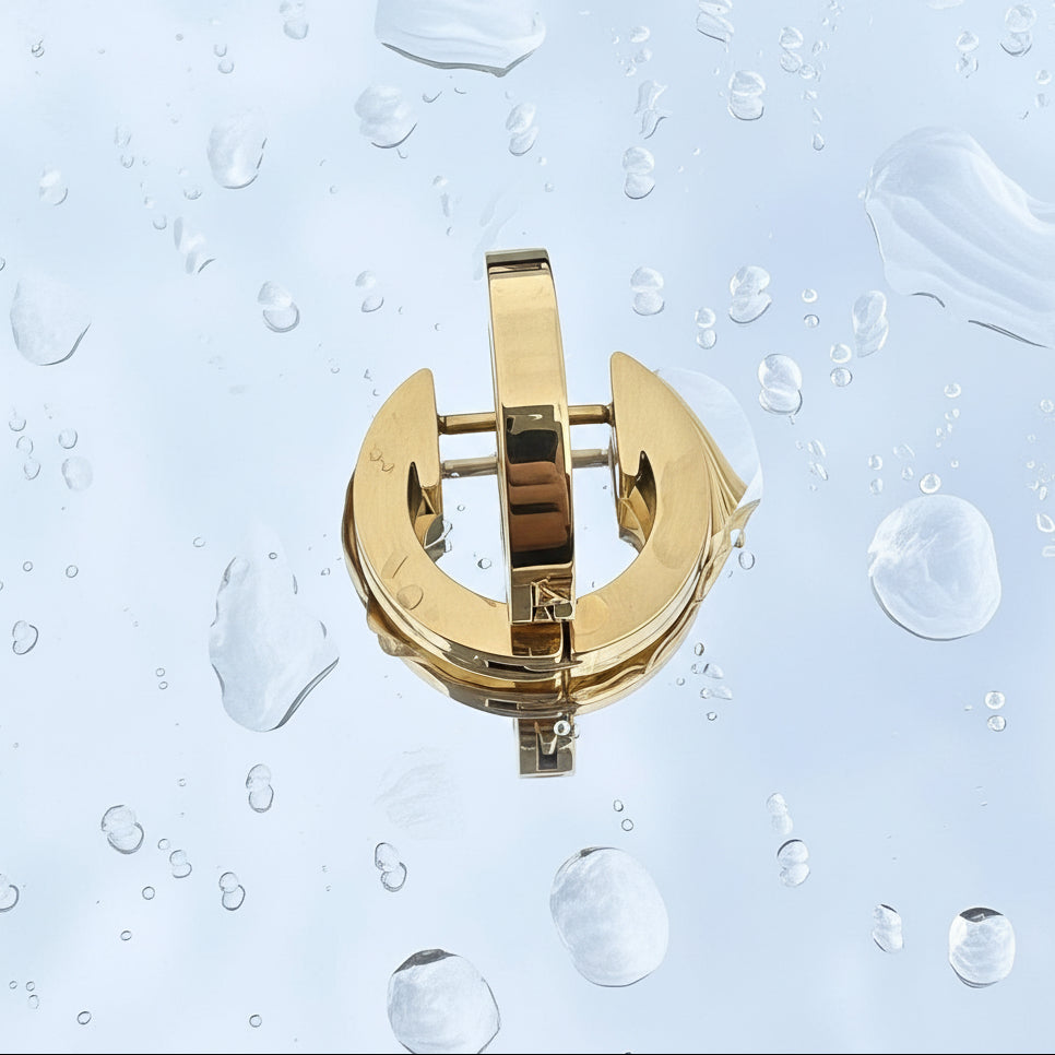 Gold earrings with gemstones on a water droplet background