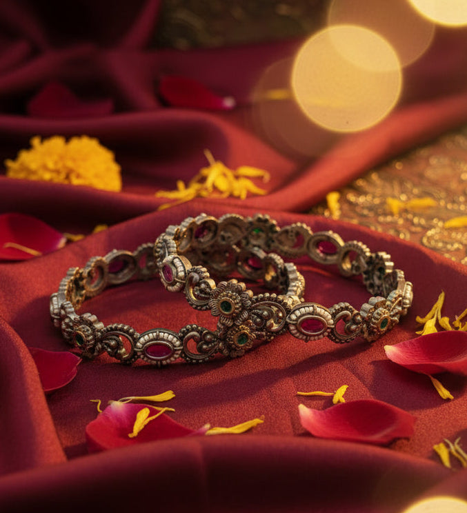Decorative bangles on a red fabric with blurred lights in the background
