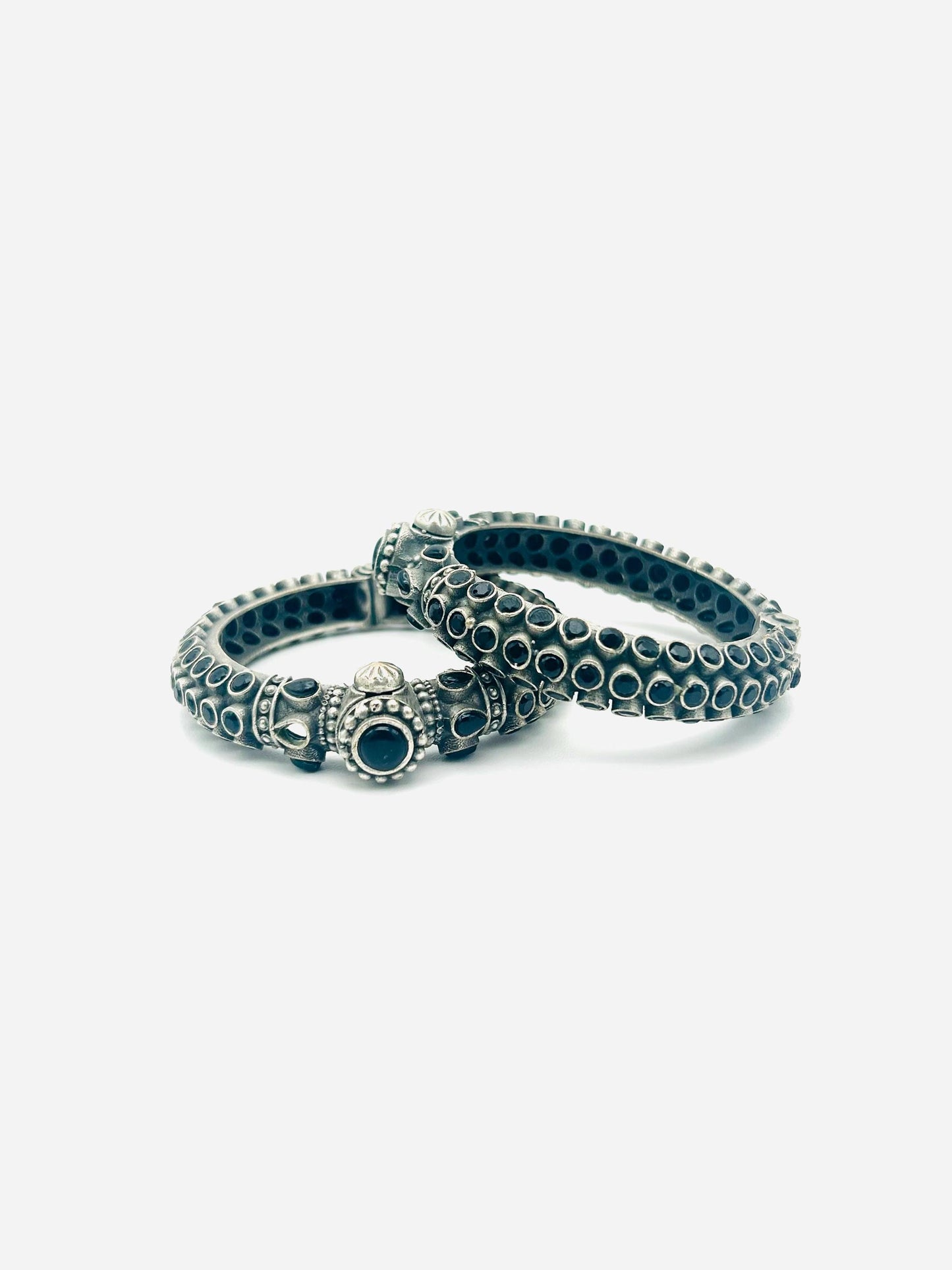 Two silver rings with black gemstones on a white background