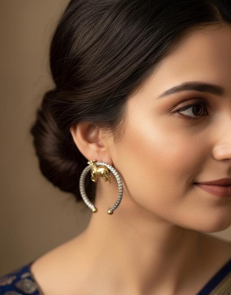 Close-up of a woman wearing a gold earring with a detailed design.