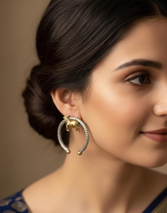 Close-up of a woman wearing a gold earring with a detailed design.