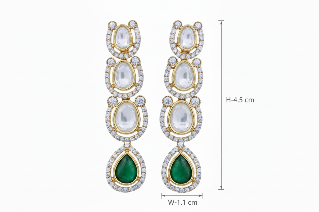 Pair of gold tone kundan drop earrings with green gemstones on a white background