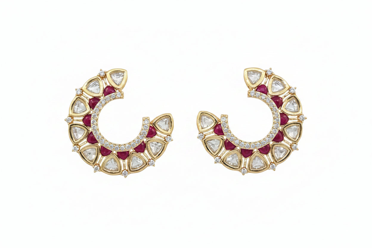 Gold tone kundan red stone earrings with red and clear gemstones on a blue background