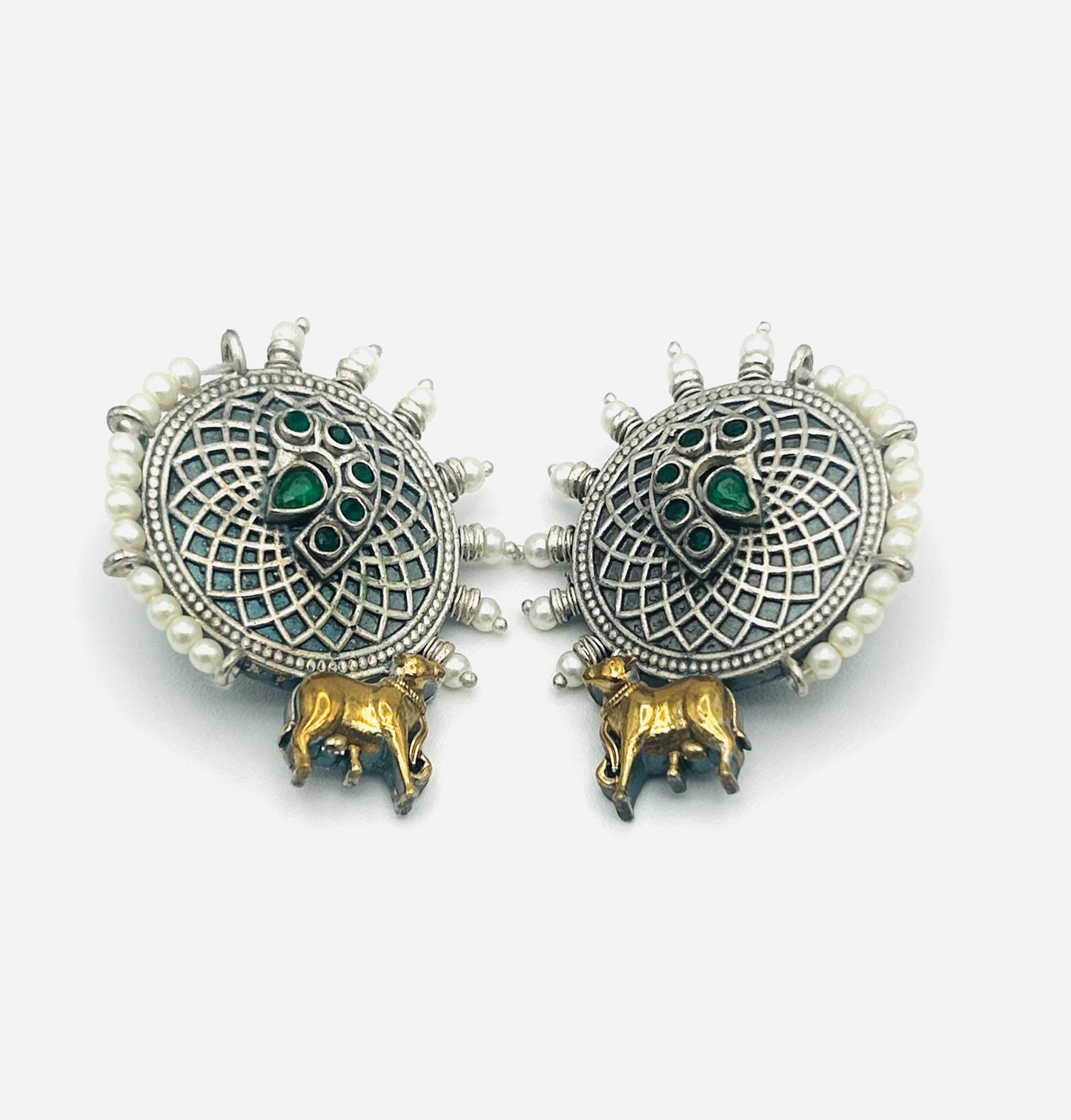 Pair of ornate earrings with green gemstones and gold accents on a white background
