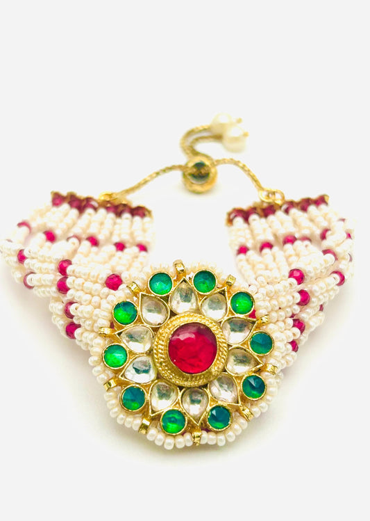 Triangular beaded necklace with green and red stones on a white background