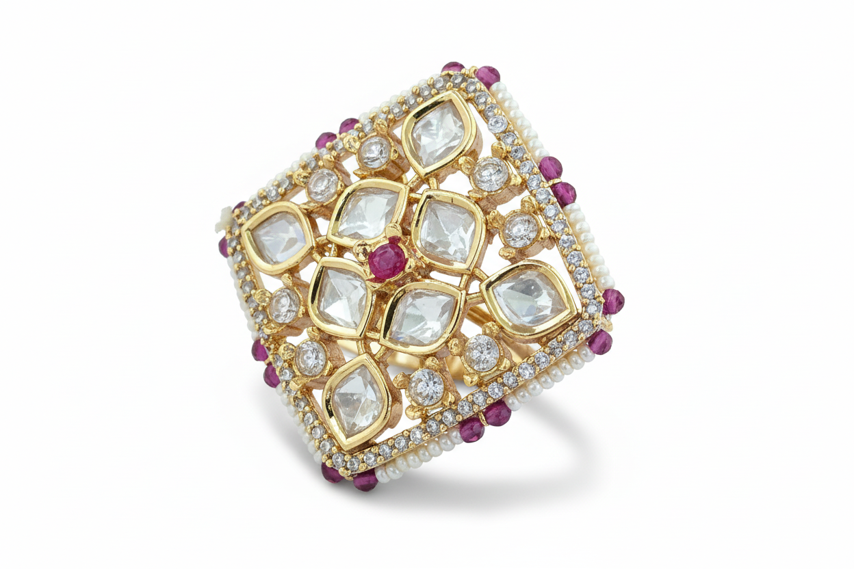 Gold plated ring with diamond and ruby stones on a white background