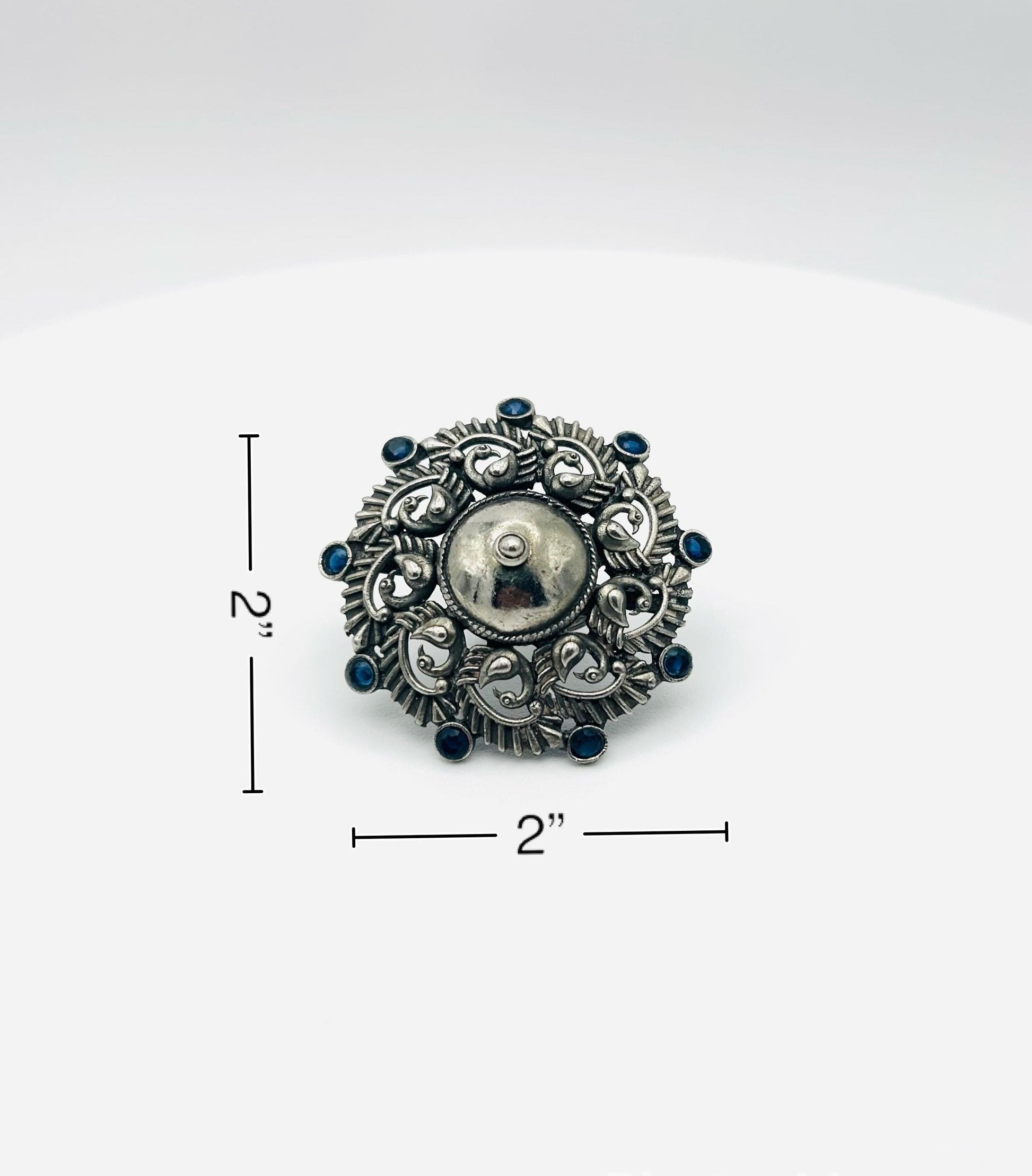 Silver brooch with blue gemstones on a white background