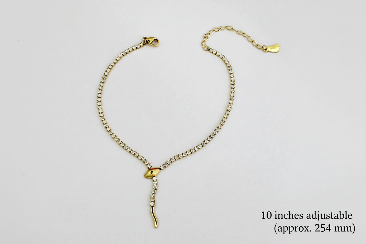 Gold anklet with a decorative clasp on a light gray background