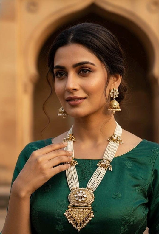 Woman wearing gold jewelry against a warm-toned architectural background