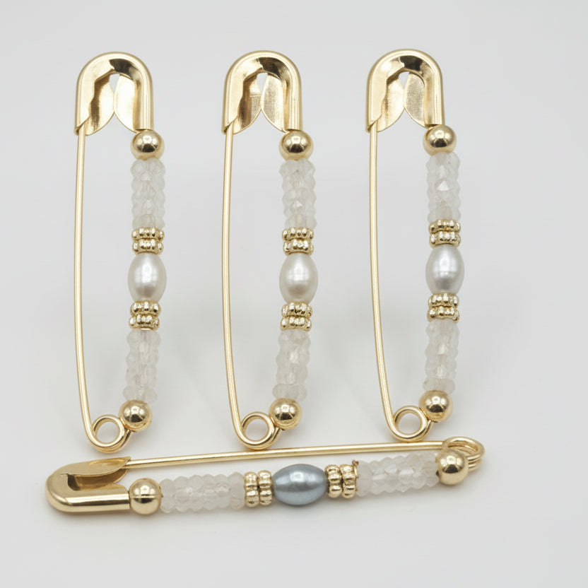 safty pins with pearl-like stones on a light gray background